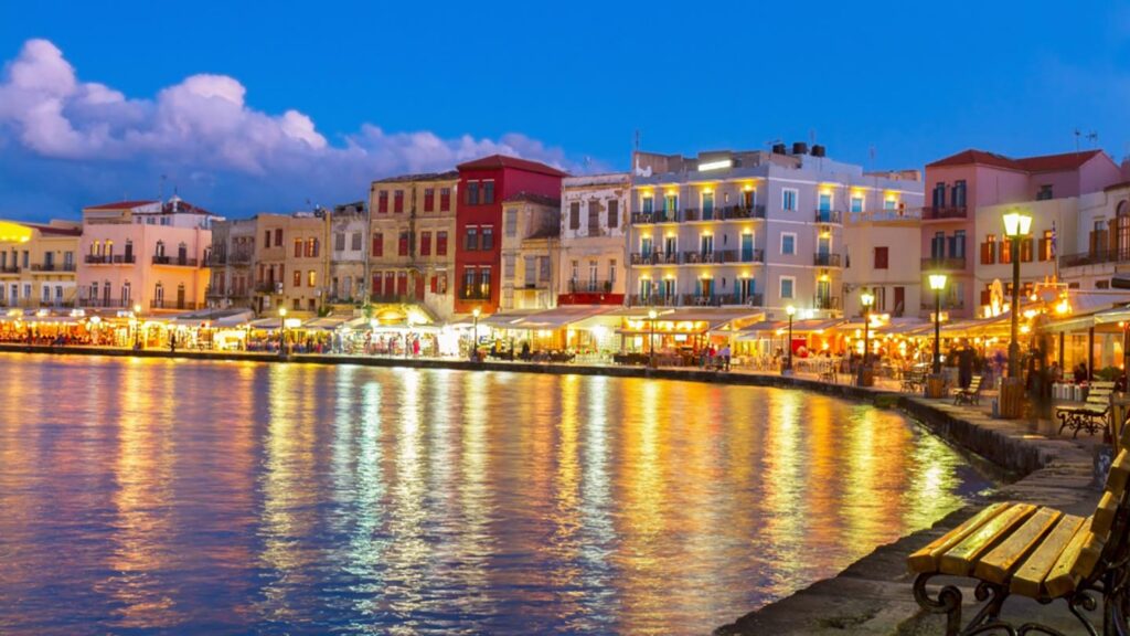 Nattliv vid vattnet i Chania, Grekland, med restauranger och färgglada byggnader.