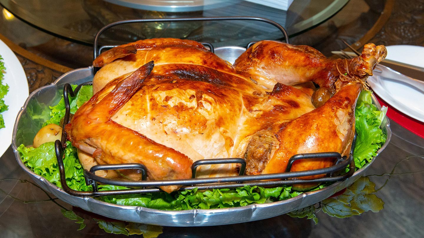 En stekt kalkon ligger på salladsblad, perfekt för Thanksgiving i USA.