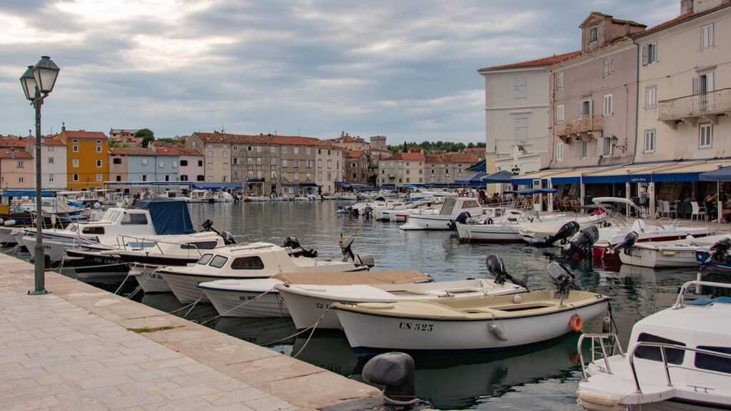 En lugn hamn i Cres, Kroatien, med många båtar och vackra byggnader.