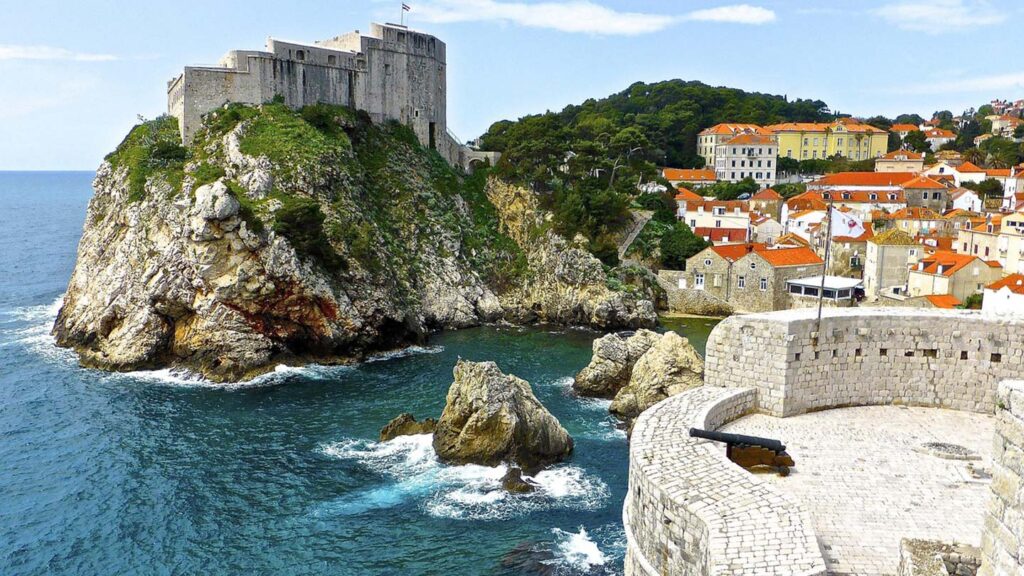 Bilden visar kustlinjen i Dubrovnik med klippor, hav och historiska byggnader.