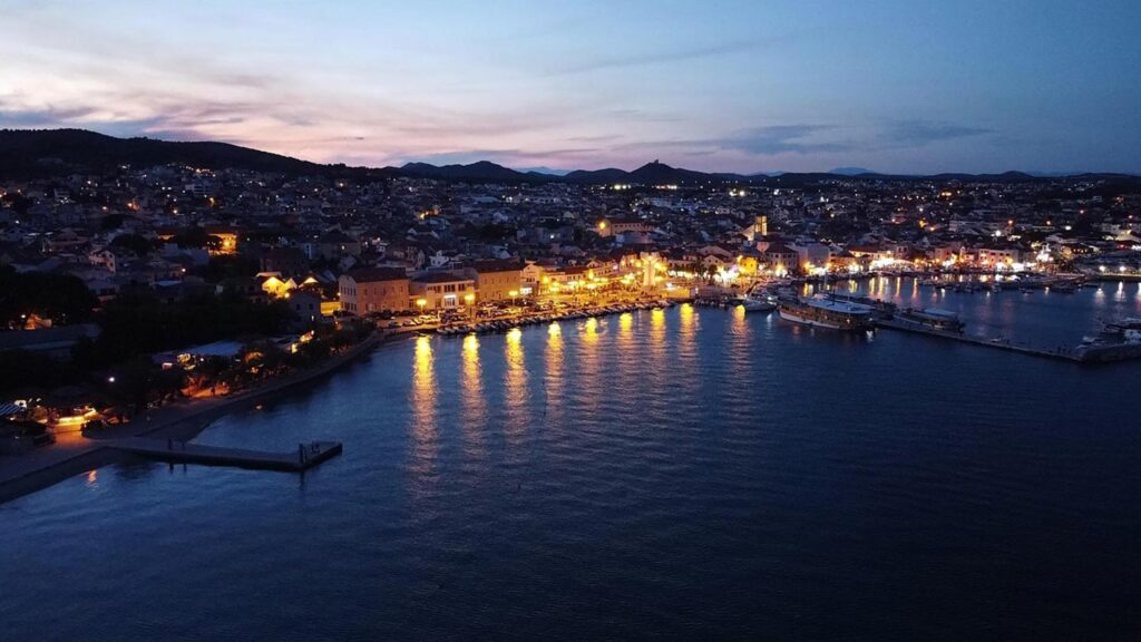 En vacker kväll i Vodice, Kroatien, med ljus som speglas i vattnet.