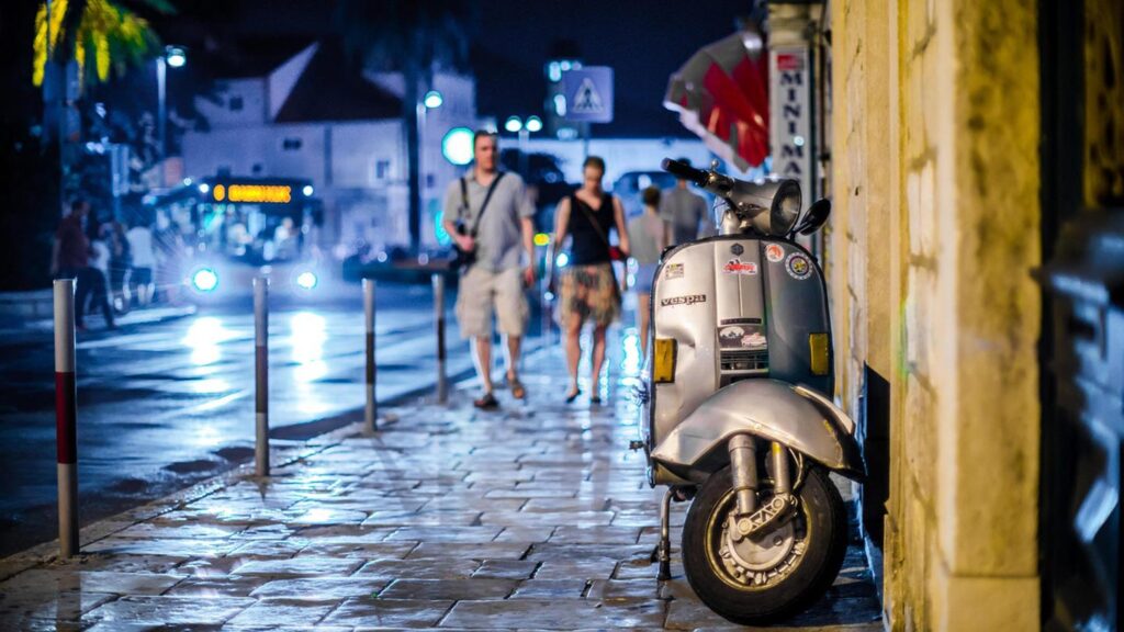 En scooter står parkerad vid en gata i Dubrovnik, Kroatien, på kvällen.
