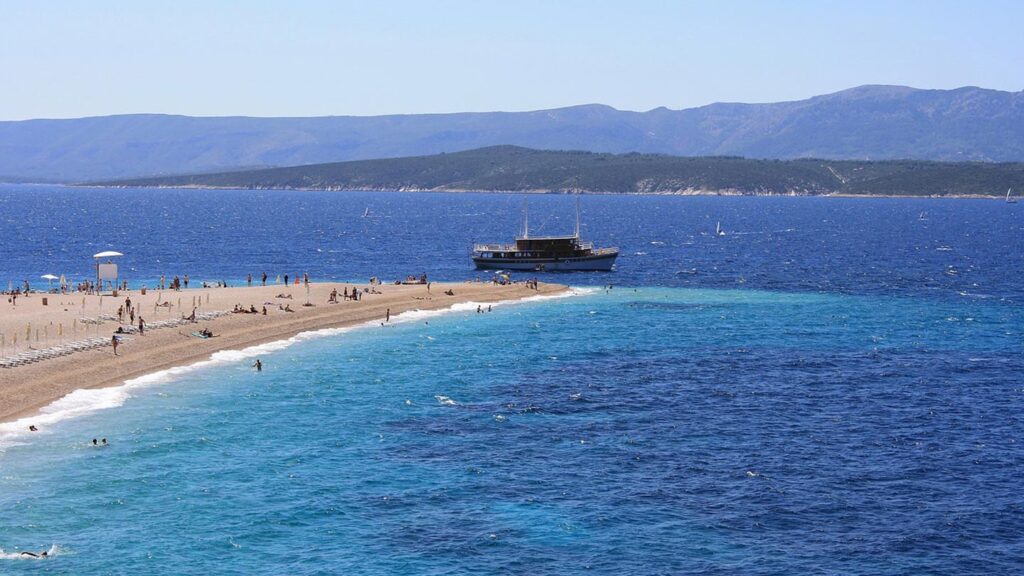En vacker strand vid Dugi Rat i Kroatien med klarblått vatten.