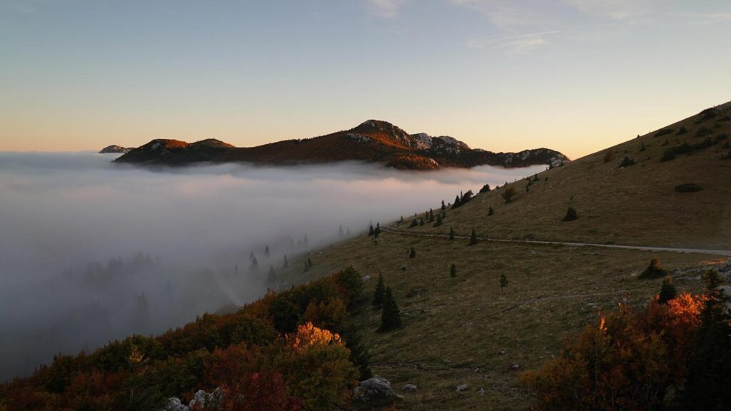 Velebitbergen i Kroatien, dimma sveper över landskapet under solnedgången.