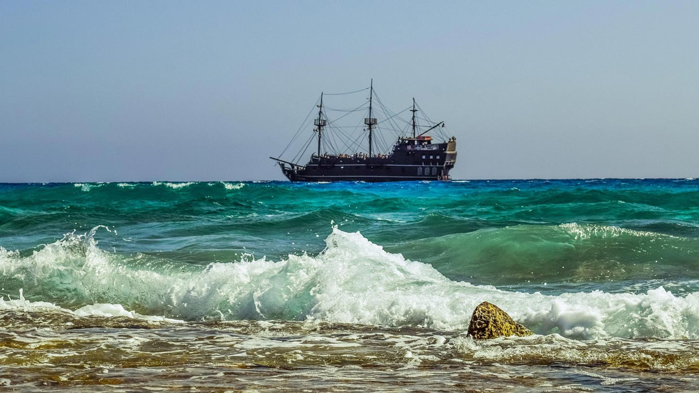 En piratskepp kryssningsfartyg seglar i det turkosa havet vid Ayia Napa, Cypern.