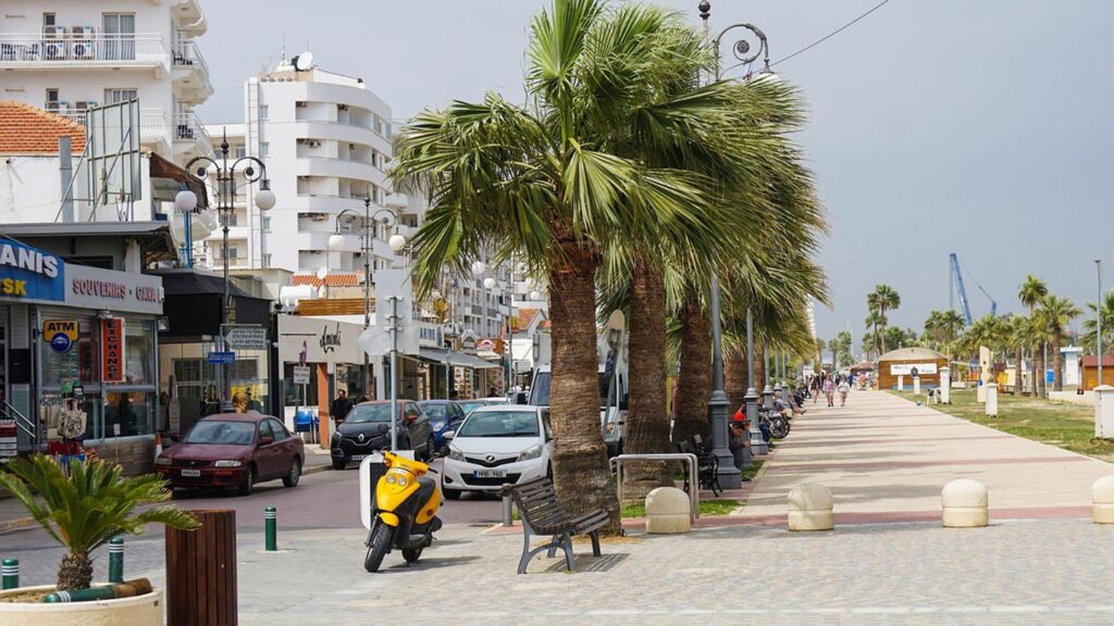 En livlig strandpromenad med palmer vid Finikoudes stranden i Larnaca, Cypern.