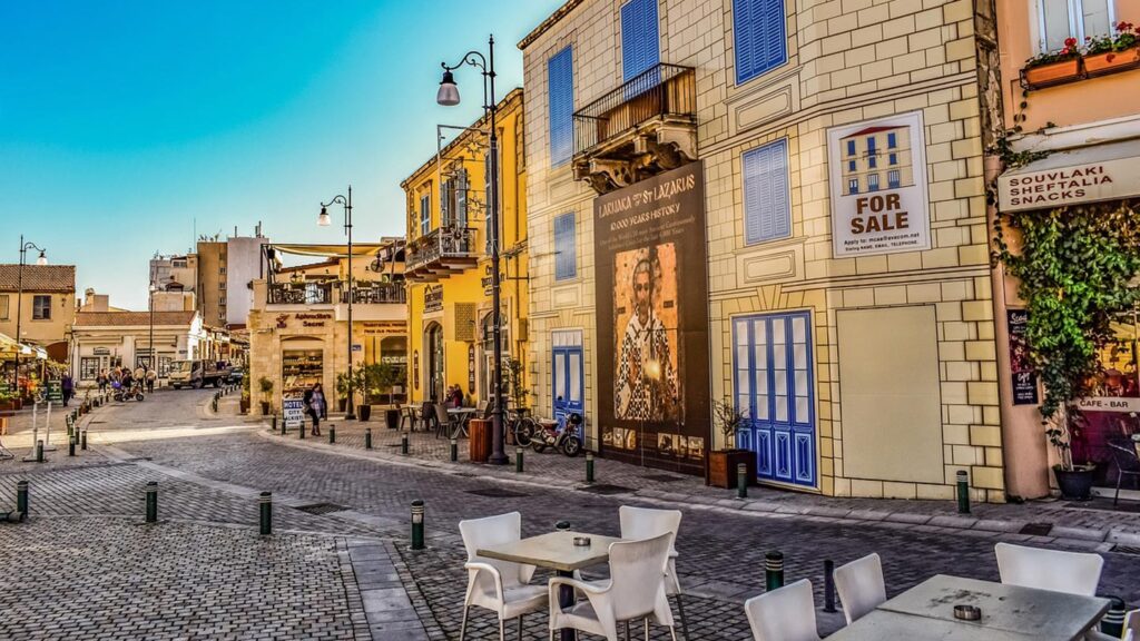 Färgglada byggnader och uteserveringar i Larnaca centrum, Cypern. Livlig shoppinggata.
