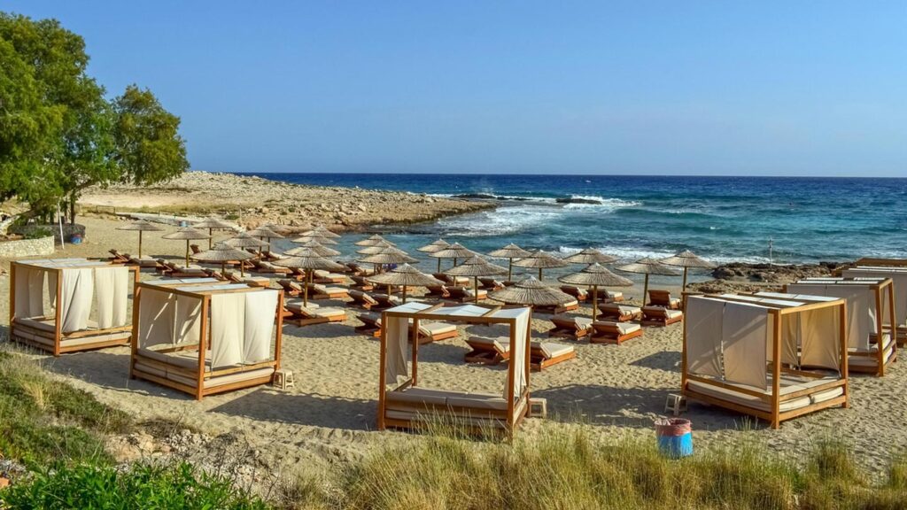 En vacker strand i Ayia Napa, Cypern, med solbäddar och parasoller.