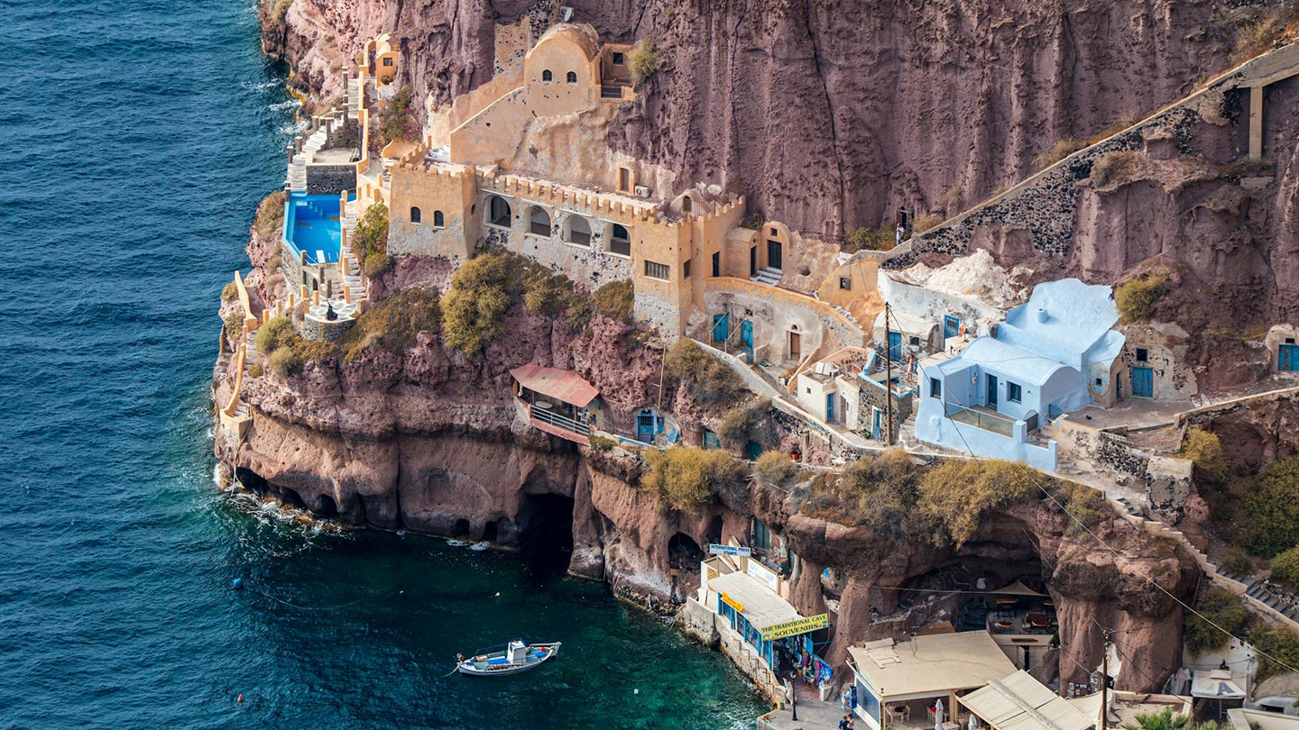 Gamla hamnen i Santorini, Grekland, med vackra hus och klarblått vatten.