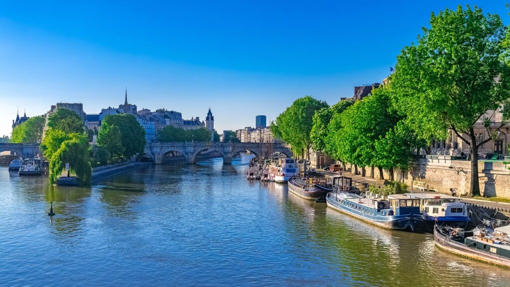 Utsikt över Pont Neuf och Île de la Cité med husbåtar i Paris.