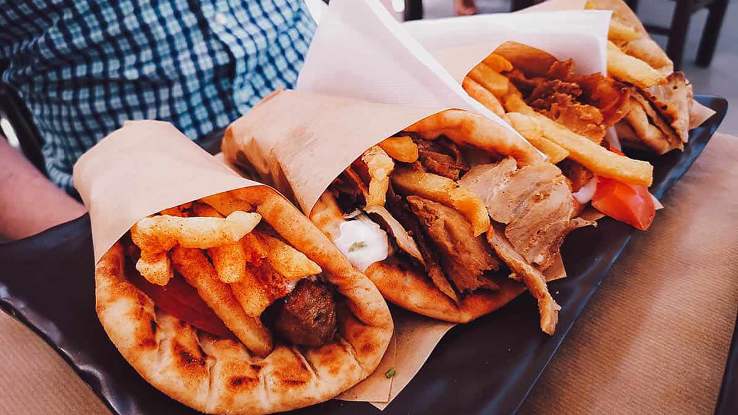 Tre pita fyllda med kött, pommes frites och grönsaker från Santorini, Grekland.