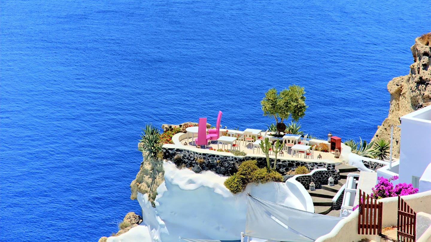 En romantisk vy från Santorini, Grekland, med blått hav och en mysig terrass.