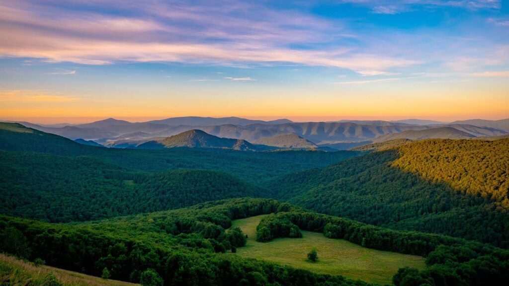 Vacker solnedgång över Bieszczady bergskedjan i Polen med gröna skogar.