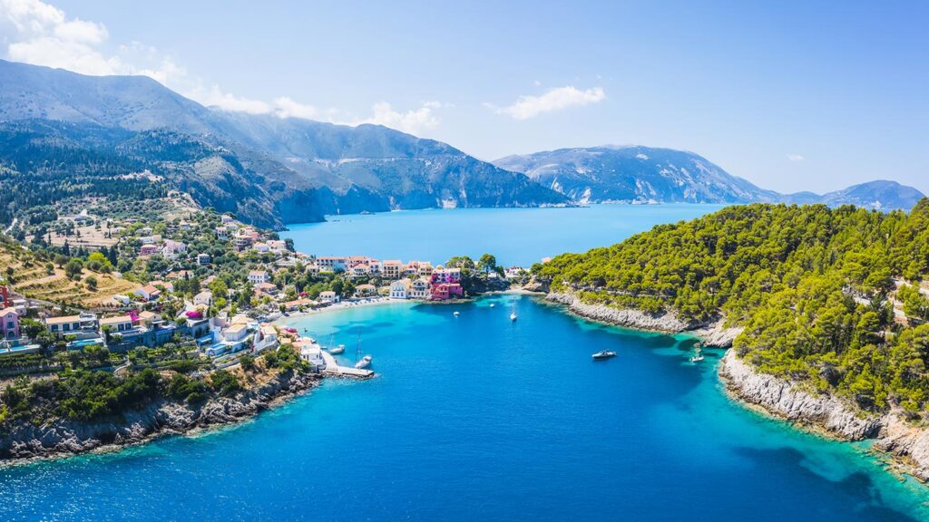 Den vackra byn Assos på Kefalonia, omgiven av blått hav och gröna berg.