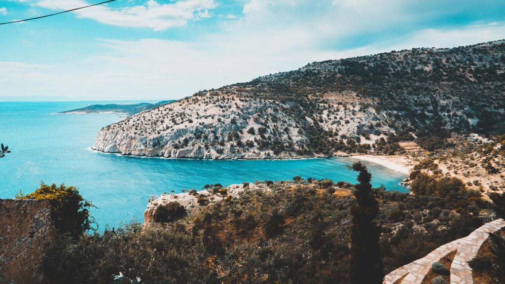Frodig grönska och klart blått hav på Thassos, Grekland. En vacker kustlinje.