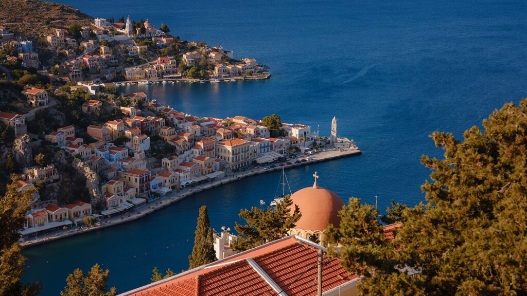 En vacker vy över hamnen i Gialos, med klocktorn på ön Symi, Grekland.