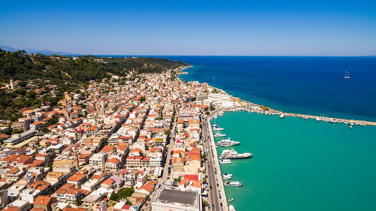 En vacker vy över hamnen i Zakynthos, med färgglada hus och klart vatten.