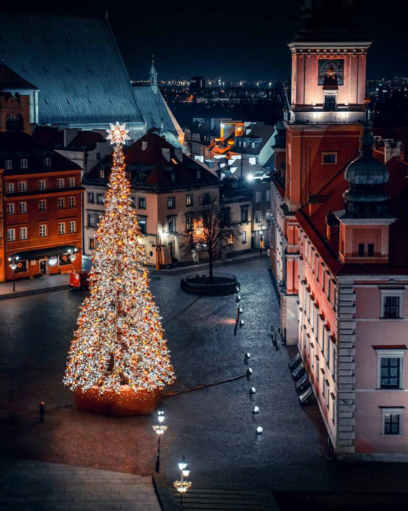 Julgran dekorerad med belysning i Warszawa, Polen, under natten.