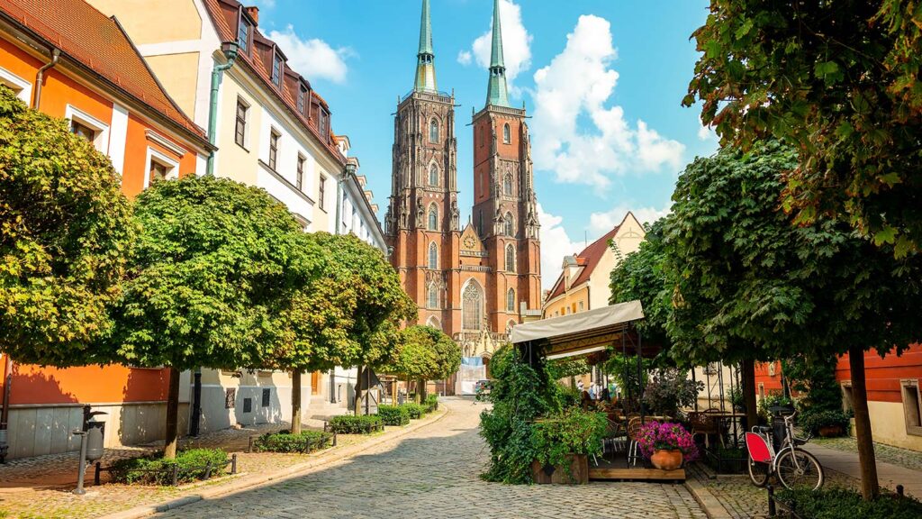 Johannes Döparens katedral i Wrocław, omgiven av träd och pittoreska byggnader.