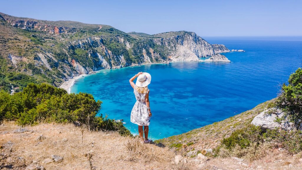 En kvinna står vid Myrtos Beach, Kefalonia, med en fantastisk havsutsikt.