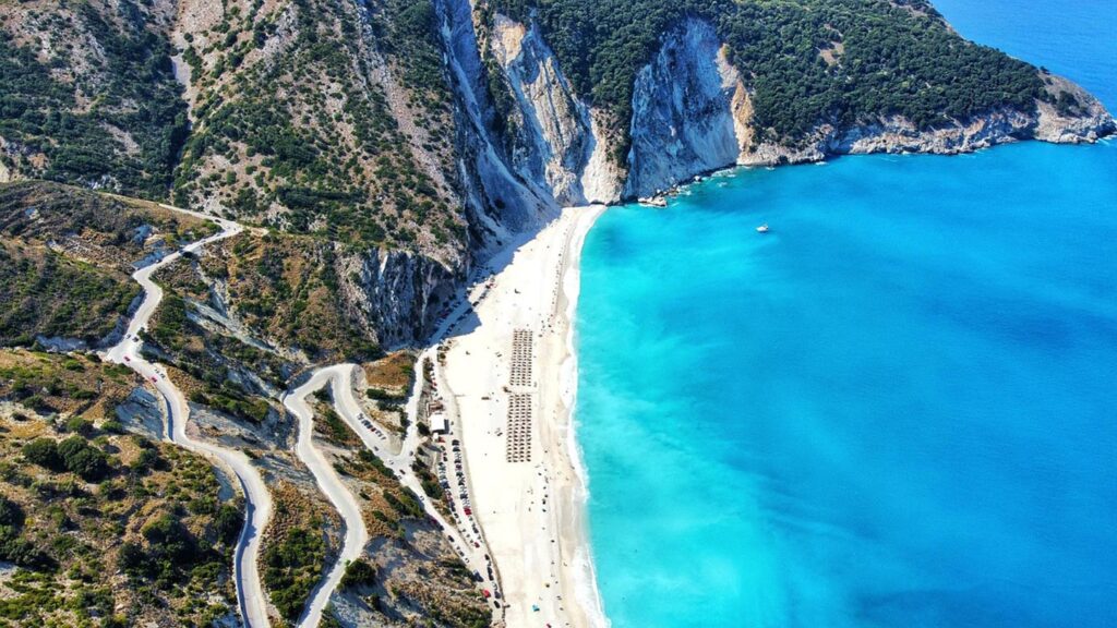 Myrtos Beach i Kefalonia har vit sand och kristallblått vatten, omgiven av berg.
