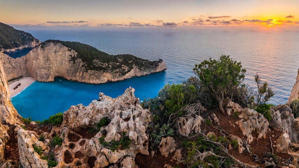 En fantastisk vy över Navagio bukten med klart blått vatten och klippor i Grekland.