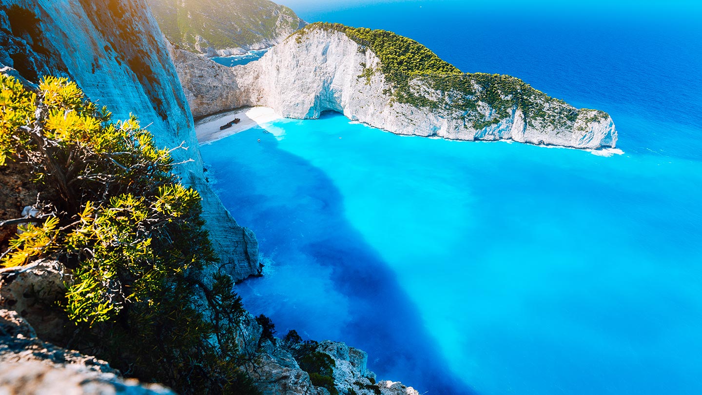 En fantastisk vy av Navagio stranden med turkost vatten och branta klippor.