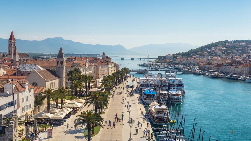 Pittoreska staden Trogir i Dalmatien med en vacker hamn och palmträd.