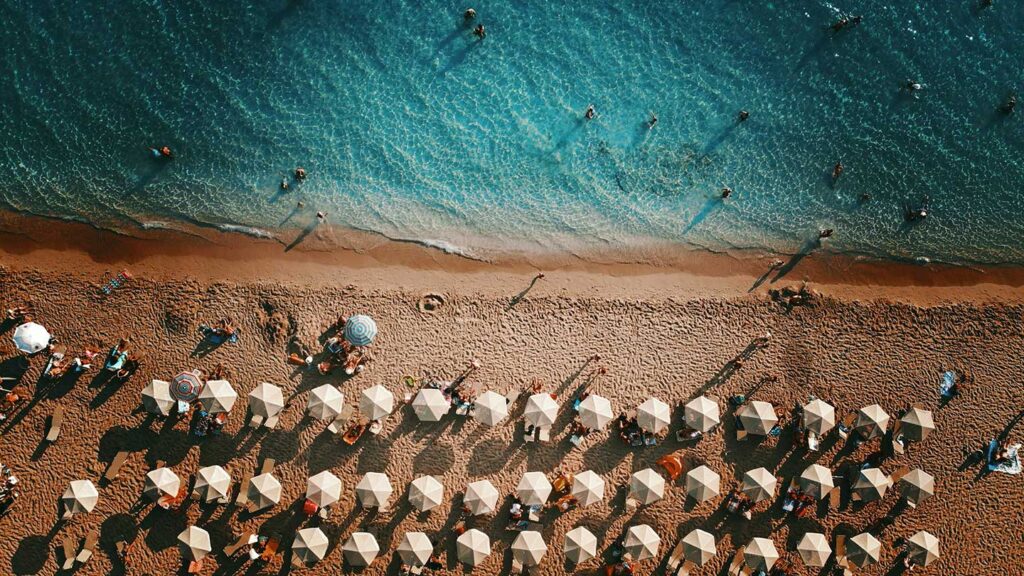 Bilden visar Platis Gialos stranden i Argostoli, Kefalonia, med solstolar och badande.