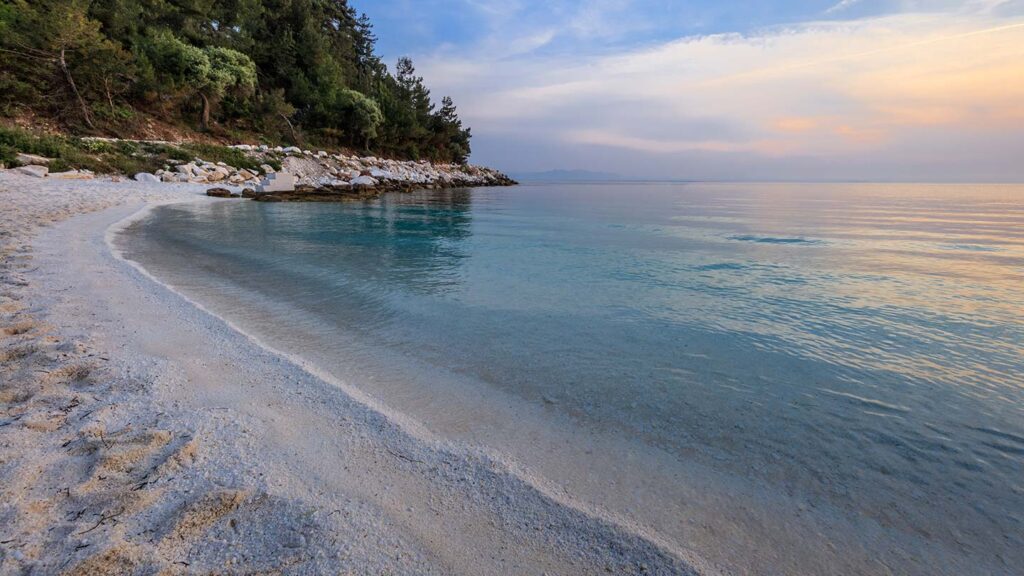 Porto Vathy, en vacker marmorstrand på Thassos, med klart Egeiskt hav.