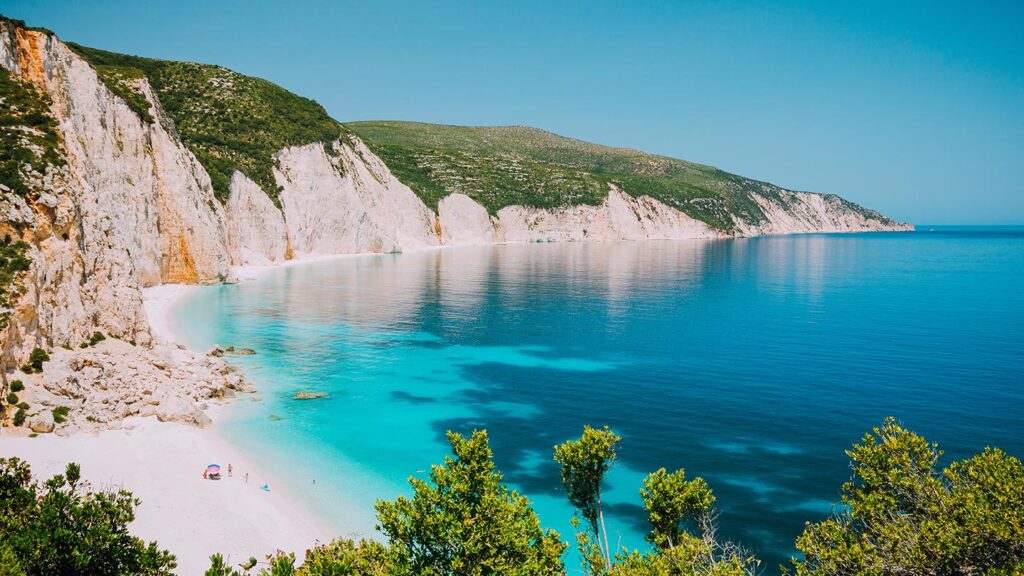 En vacker lagun vid Fteri stranden i Kefalonia, med klippig kustlinje och klart vatten.