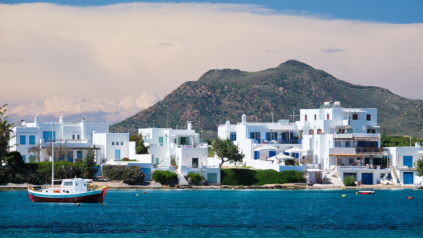 Pollonia på Milos har vita hus, blå detaljer och en vacker strand.