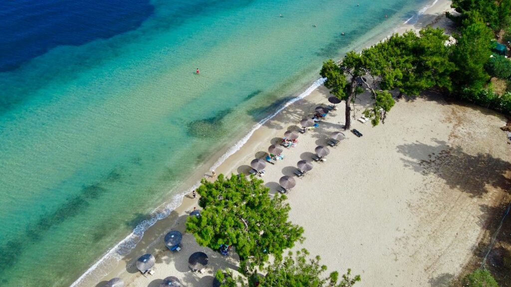En vacker strand på Thassos, Grekland, med solstolar och parasoller.