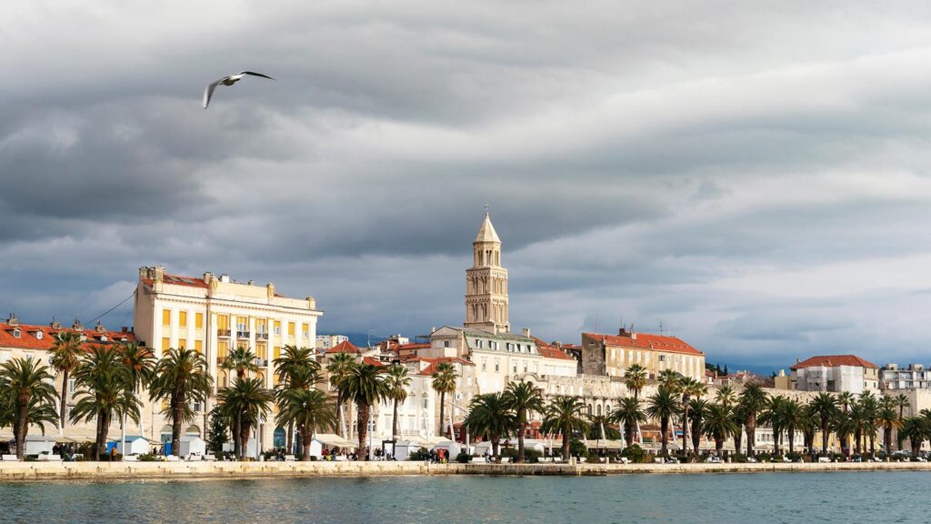 En vacker strandpromenad i Split, Kroatien, med palmer och historiska byggnader.