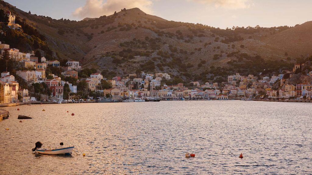 Bild av Symi ön i Dodekaneserna med färgglada hus vid havet.
