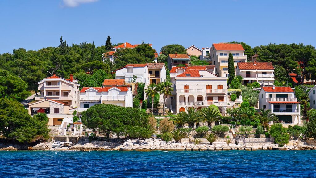 Bild av Trogirs skärgård i Dalmatien, Kroatien, med vackra hus och grönska.