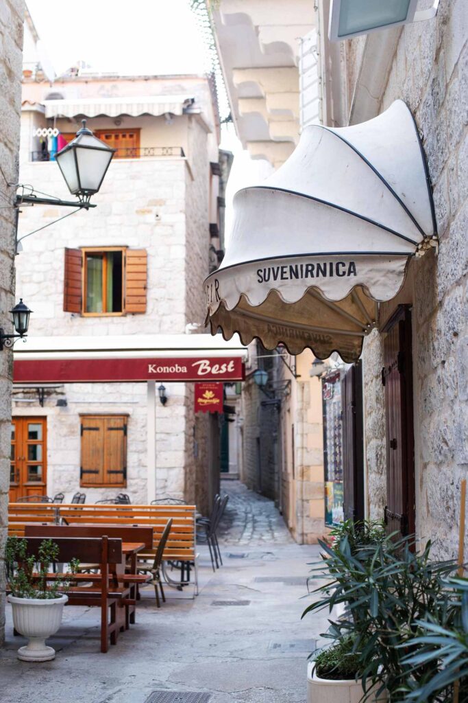 Uteservering i Trogir, Kroatien, med gamla byggnader och mysig atmosfär.