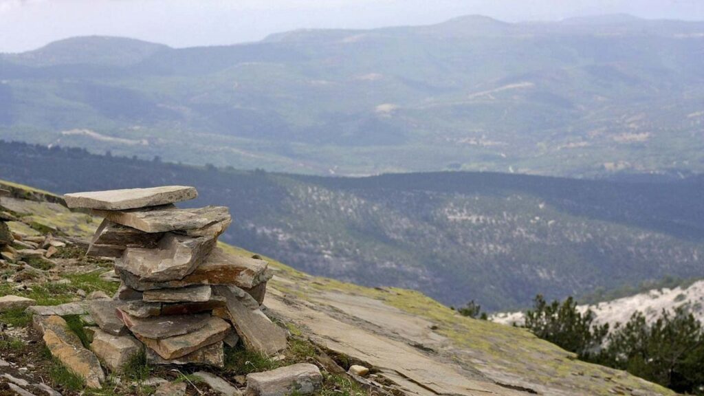 Bilden visar en stenur på Thassos, med vackra berg i bakgrunden.