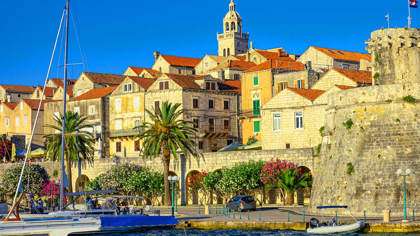Pittoreska staden Korčula i Kroatien med vackra byggnader och palmer.