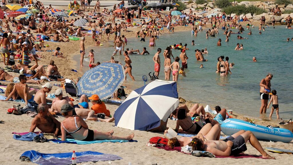 Stranden i La Ciotat, Marseille, full av solande och simmande människor.