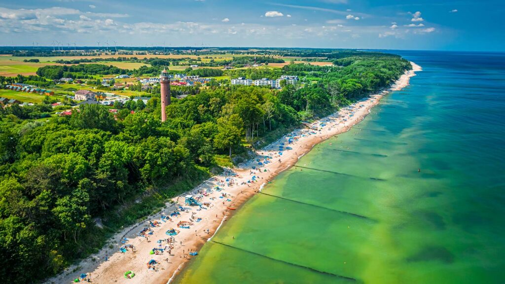 En vacker strand vid Östersjön i Polen, med många solbesökare och grönska.