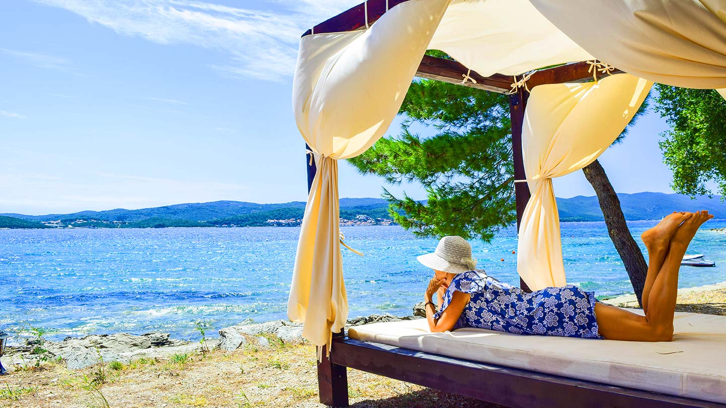 En kvinna kopplar av på en strandbädd i Korčula, Kroatien.