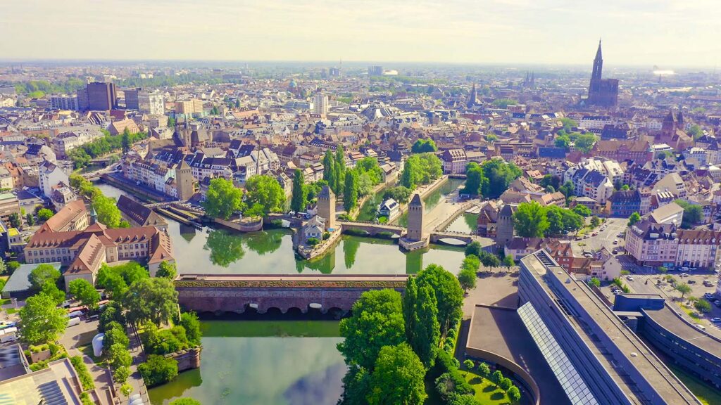 Bilden visar Gamla kvarteret Petite France i Strasbourg, omgiven av grönska och vatten.