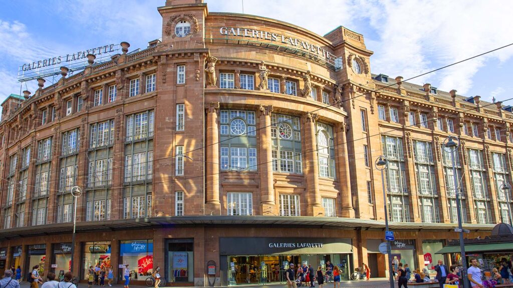 Bilden visar Galeries Lafayette i centrala Strasbourg, Frankrike, med många besökare.