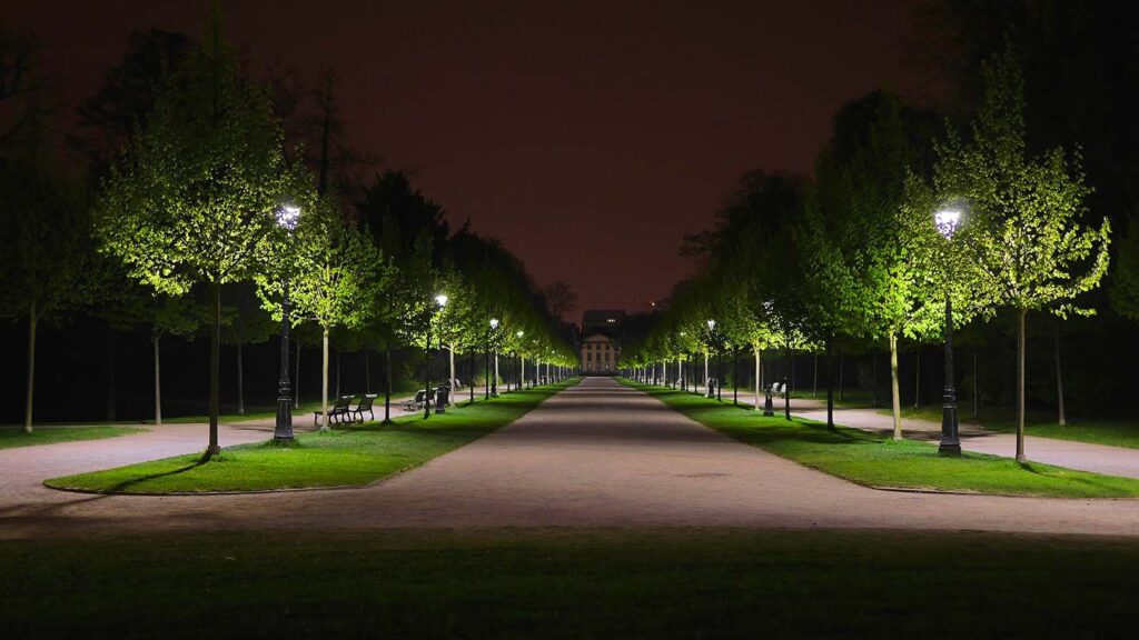 Orangeriet i Strasbourg är vackert upplyst på natten, omgiven av träd och promenader.