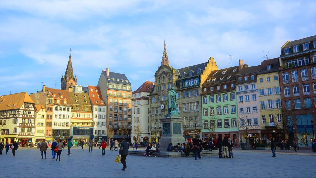 Place Kléber i Strasbourg, Frankrike, med historiska byggnader och människor som promenerar.