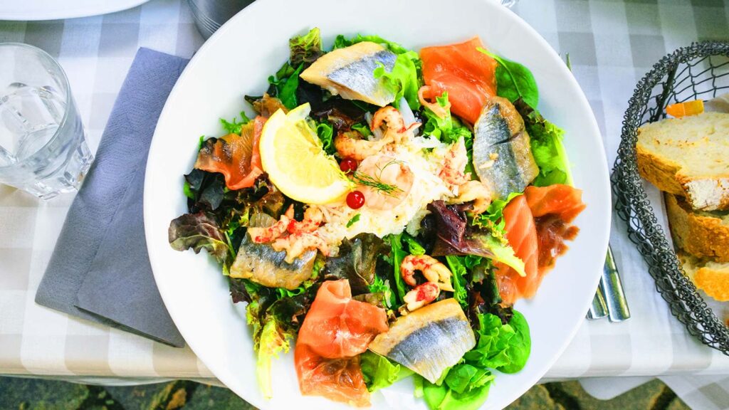 En stor sallad med fisk serveras på uteservering i Strasbourg, Frankrike.