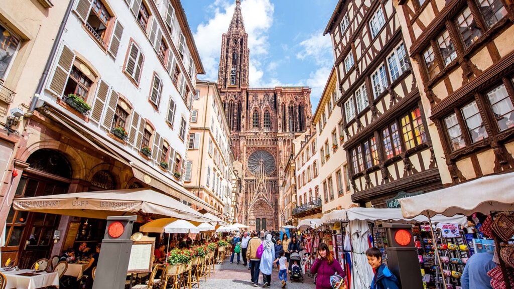 Utsikt över en trång gata med gamla byggnader och Notre Dame i Strasbourg.