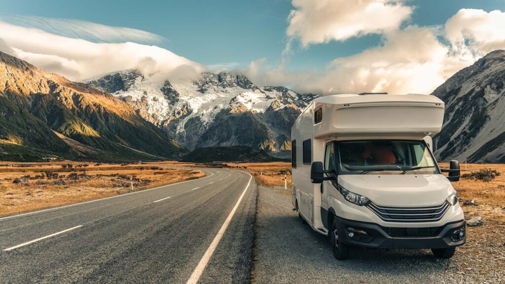 En husbil står parkerad vid vägkanten, med Mount Cook i bakgrunden.