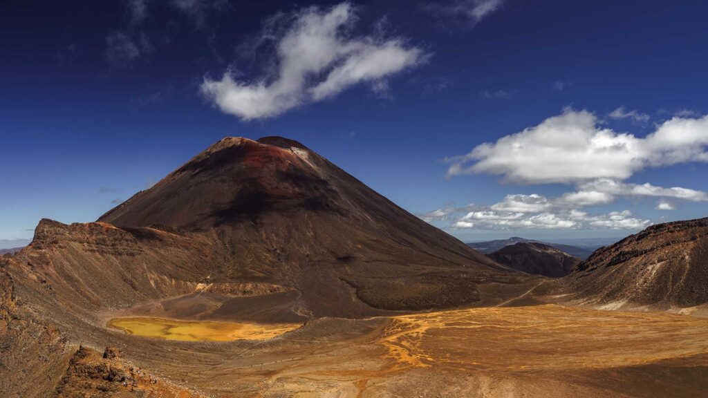 Bilden visar Mount Dome, en imponerande vulkan med dramatisk landskap och blå himmel.